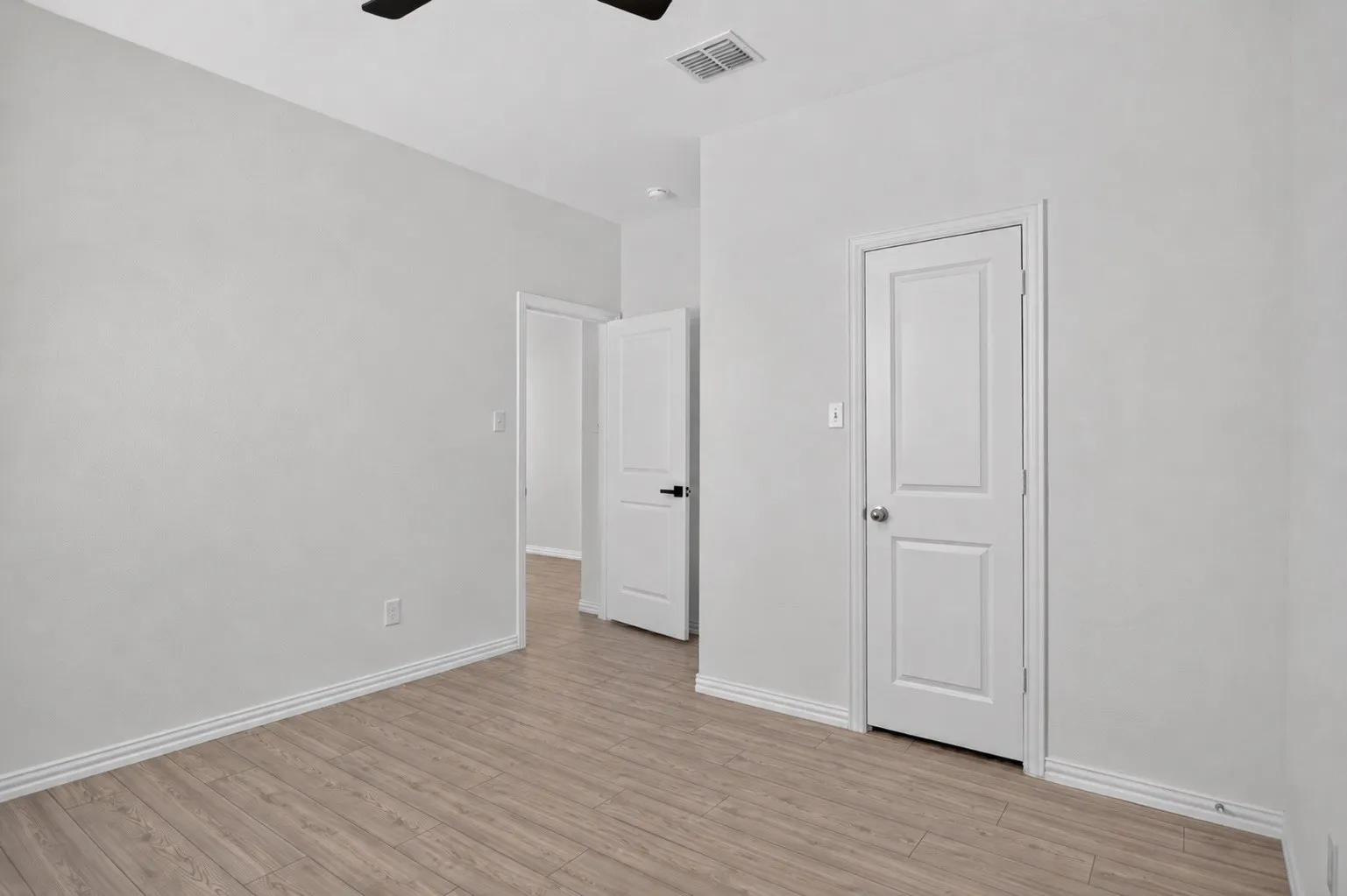 Wood-finish flooring, white trim, and light gray walls