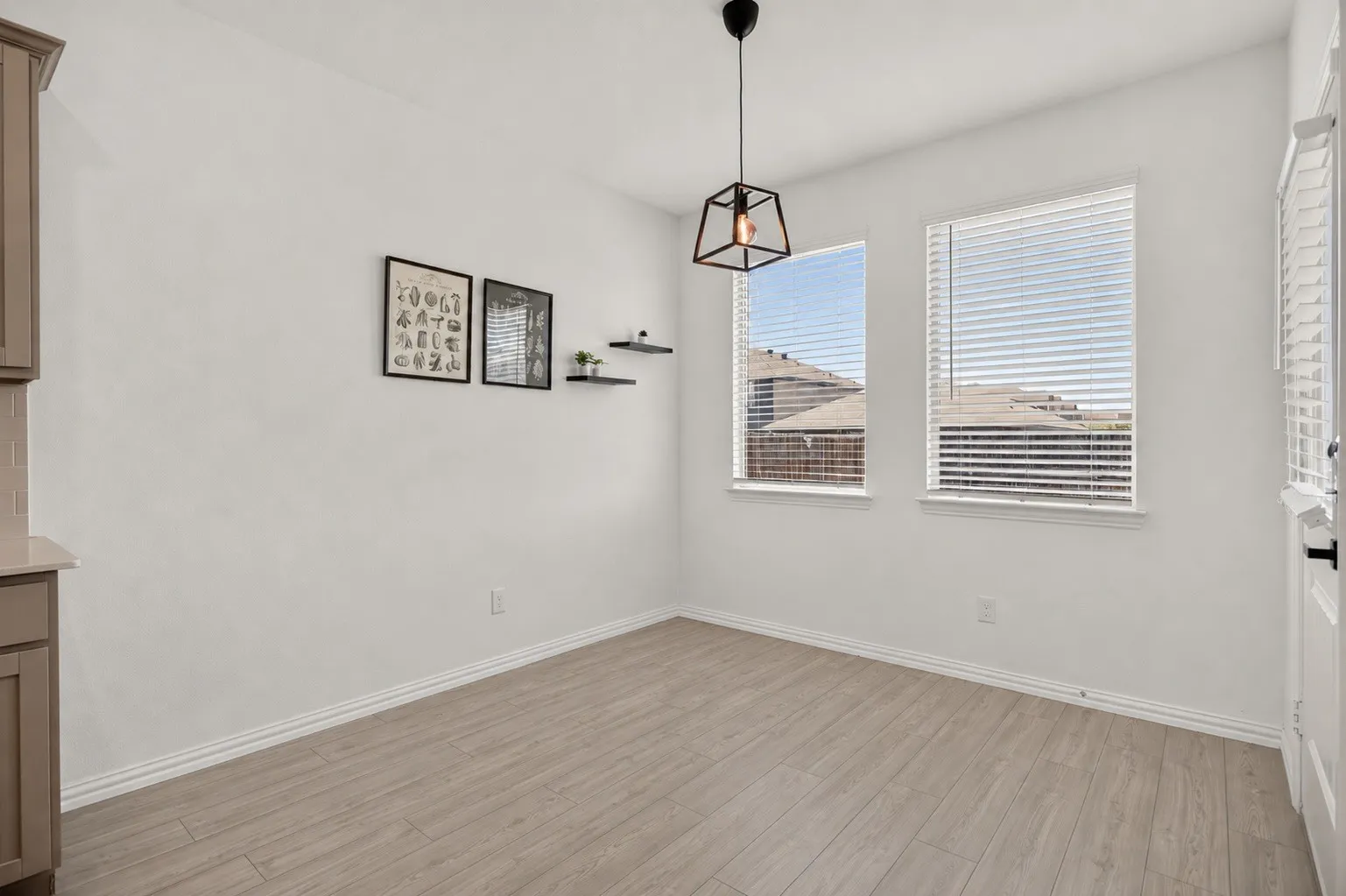Wood-finish flooring, two large windows with blinds, a modern pendant light fixture, and white painted walls