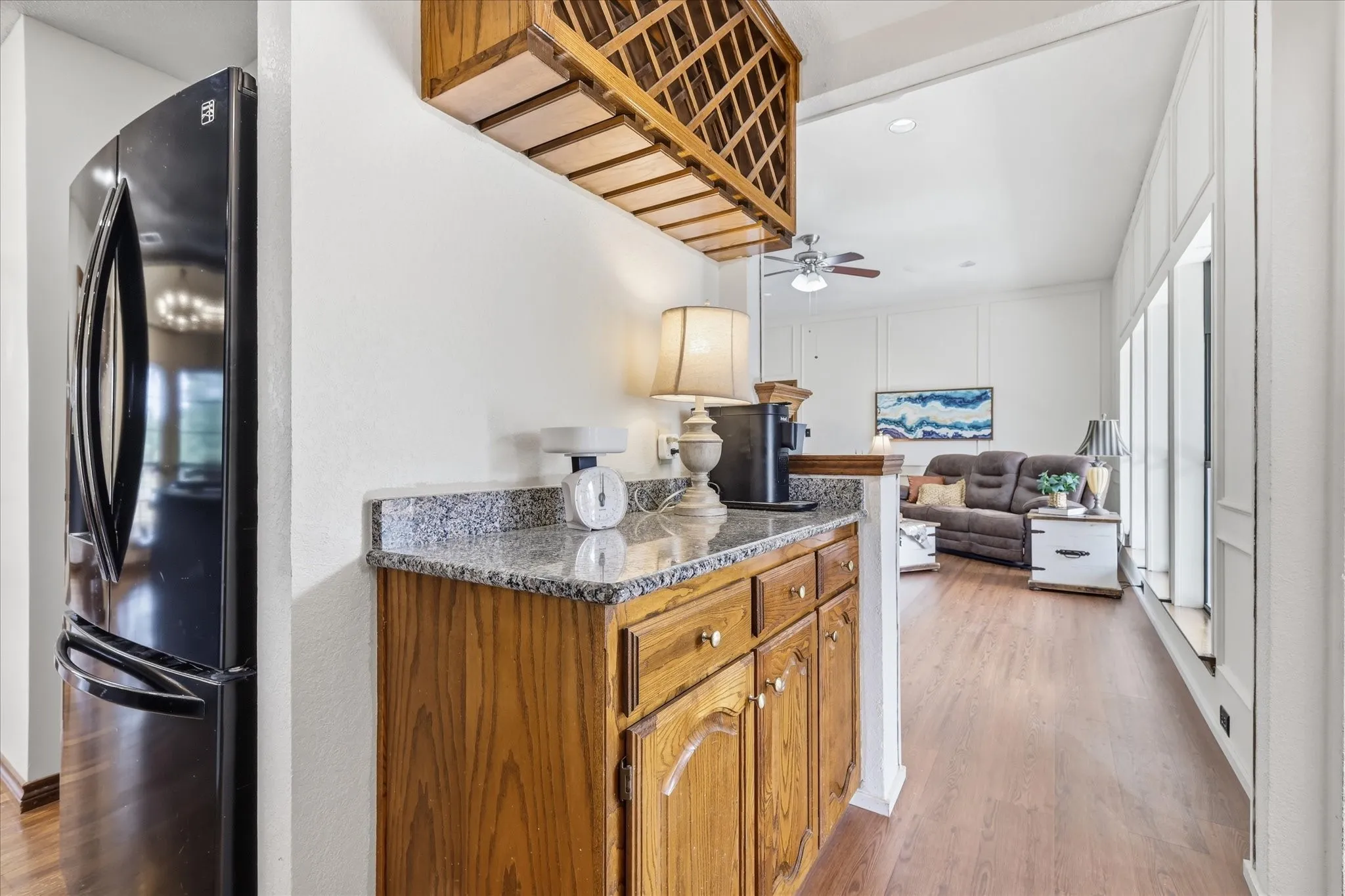 Built-in wooden cabinetry with granite-look countertop and overhead wine storage
