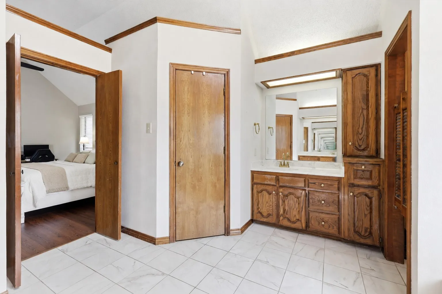 Double vanity with wood cabinetry, integrated sink, and overhead lighting
