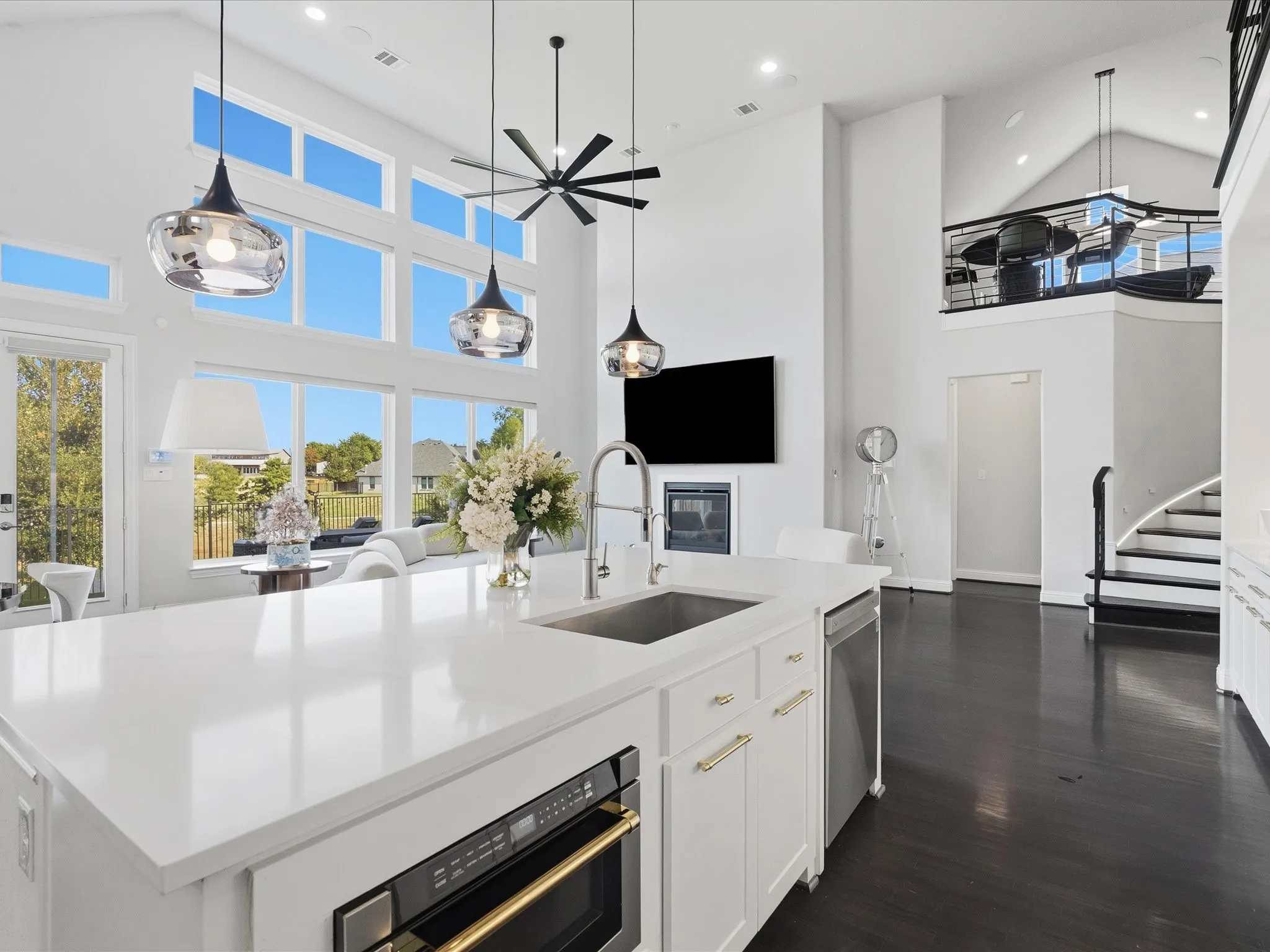 Spacious kitchen with a large island featuring a stainless steel sink and integrated microwave