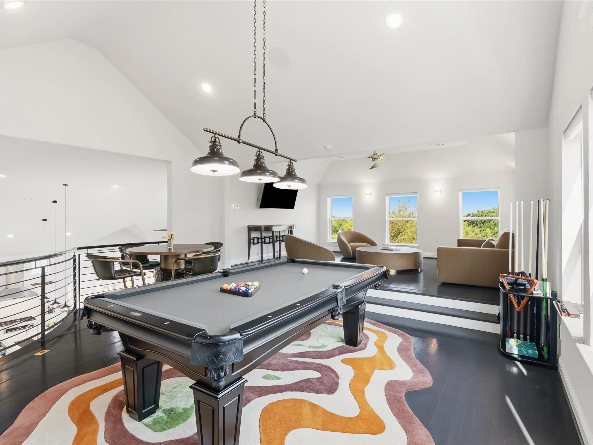 Open-concept bonus room with dark-finish flooring, vaulted ceiling, and recessed lighting