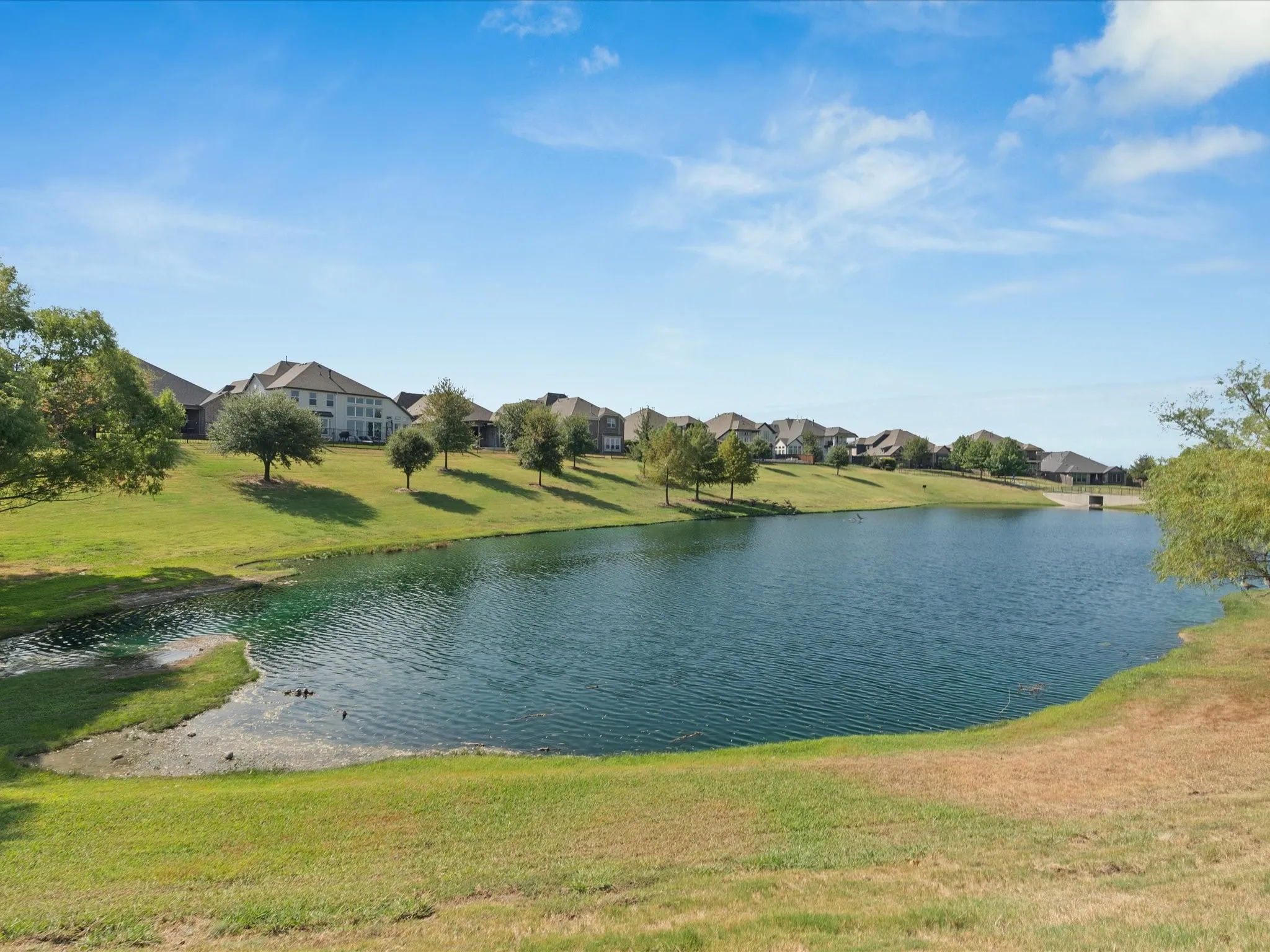 Lush green landscaping with a prominent pond