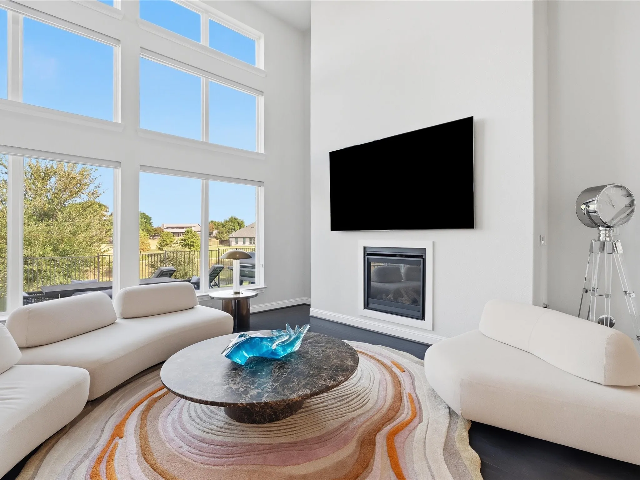 Two-story wall of windows, dark wood-finish flooring, built-in fireplace, and high ceilings