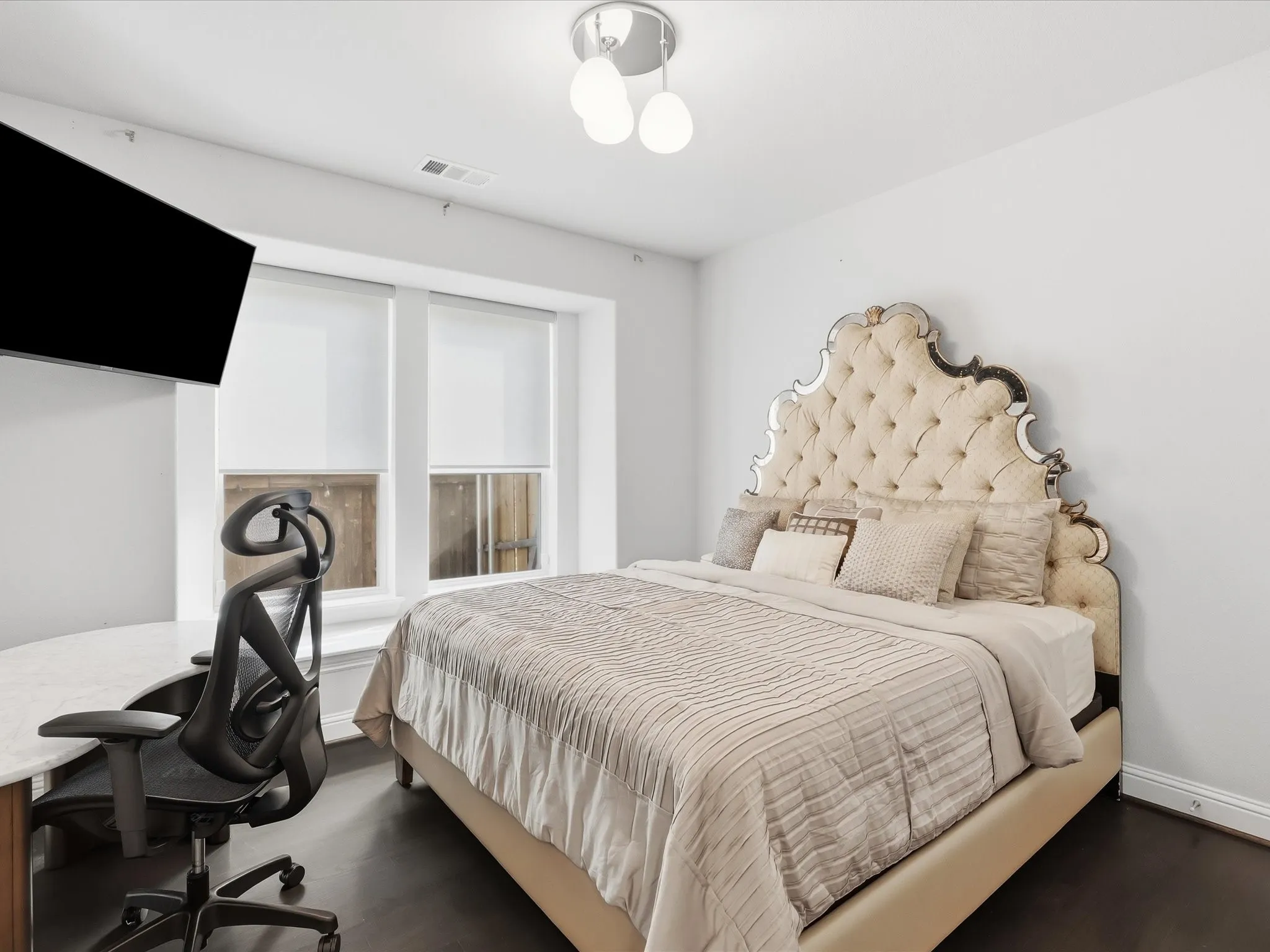 Expansive windows with roller shades, recessed ceiling lighting, wall-mounted television, and wood-finish flooring