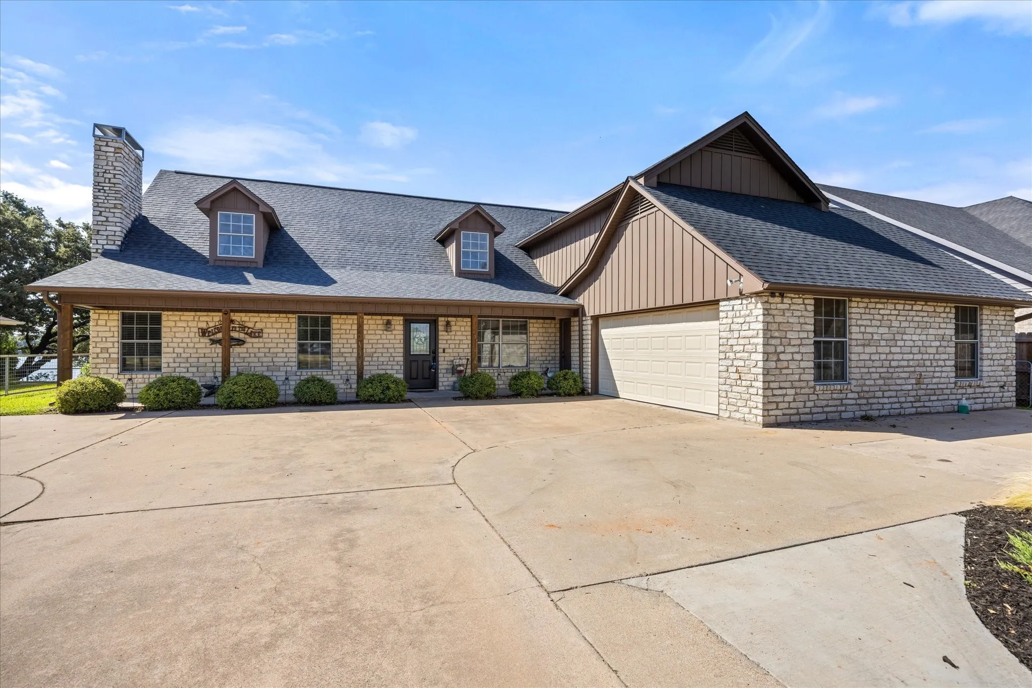 Elegant brick and stone exterior with a mansard roof featuring dormer windows and architectural detailing