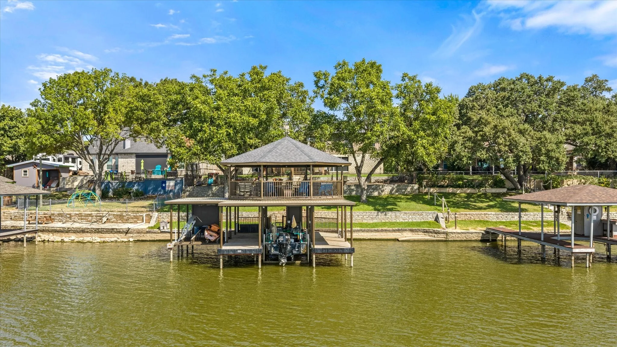 Two-story boat dock with an upper-level covered deck, a lower-level boat slip, and an additional covered boat slip