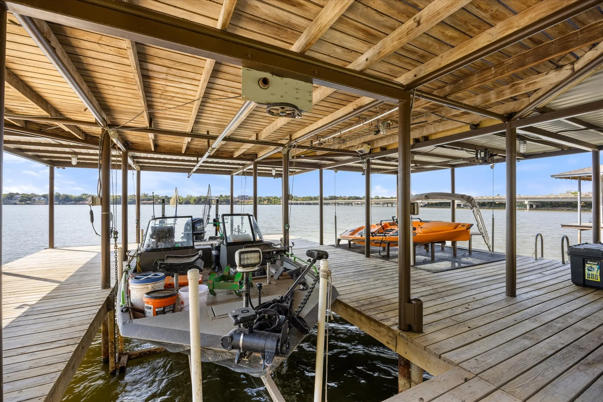 Covered boat dock featuring wood-finish decking, sturdy support posts, and direct water access