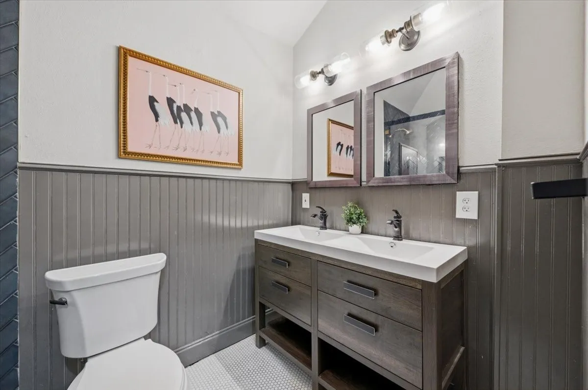 Double vanity with integrated sinks, dark wood-finish cabinetry, and matte black fixtures