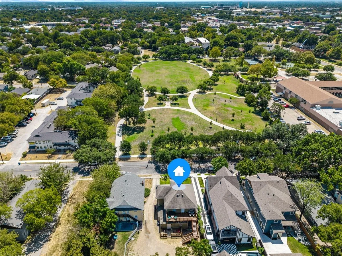 Aerial perspective highlighting urban surroundings, expansive green spaces, and dense tree coverage