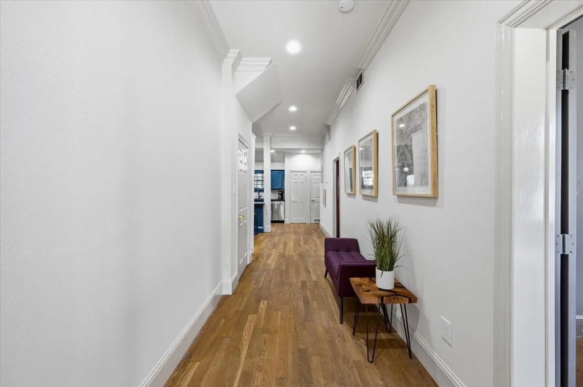 Recessed lighting, crown molding, wood-finish flooring, and crisp white walls throughout