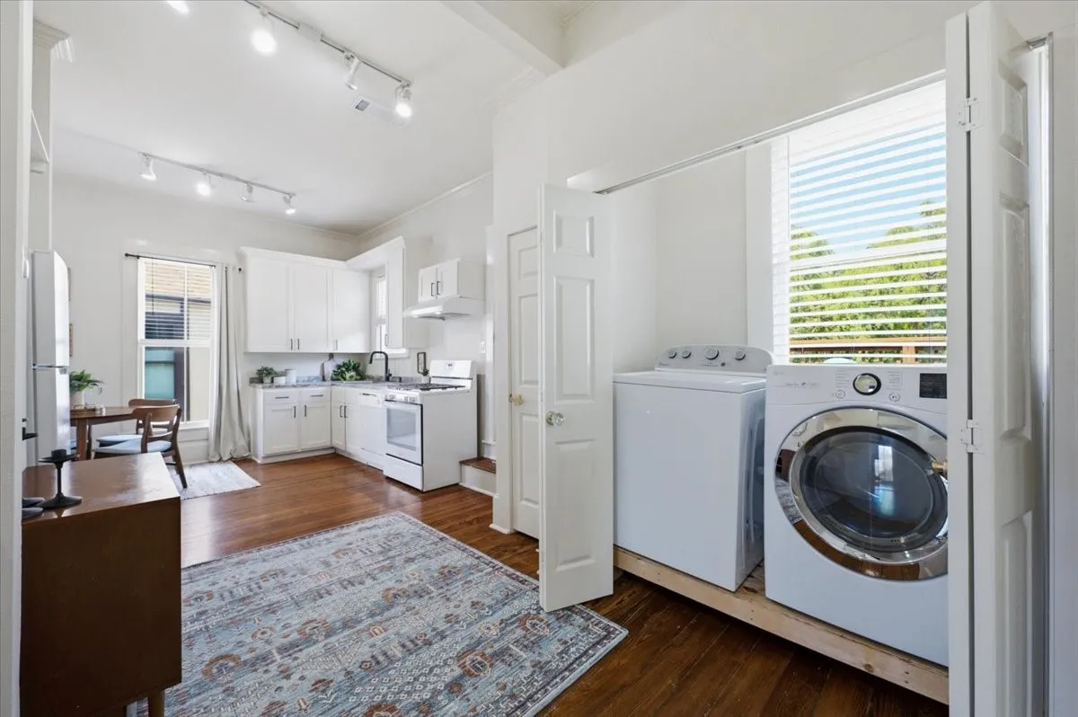 Efficient kitchen area featuring white cabinetry, a built-in range, and a stainless steel sink