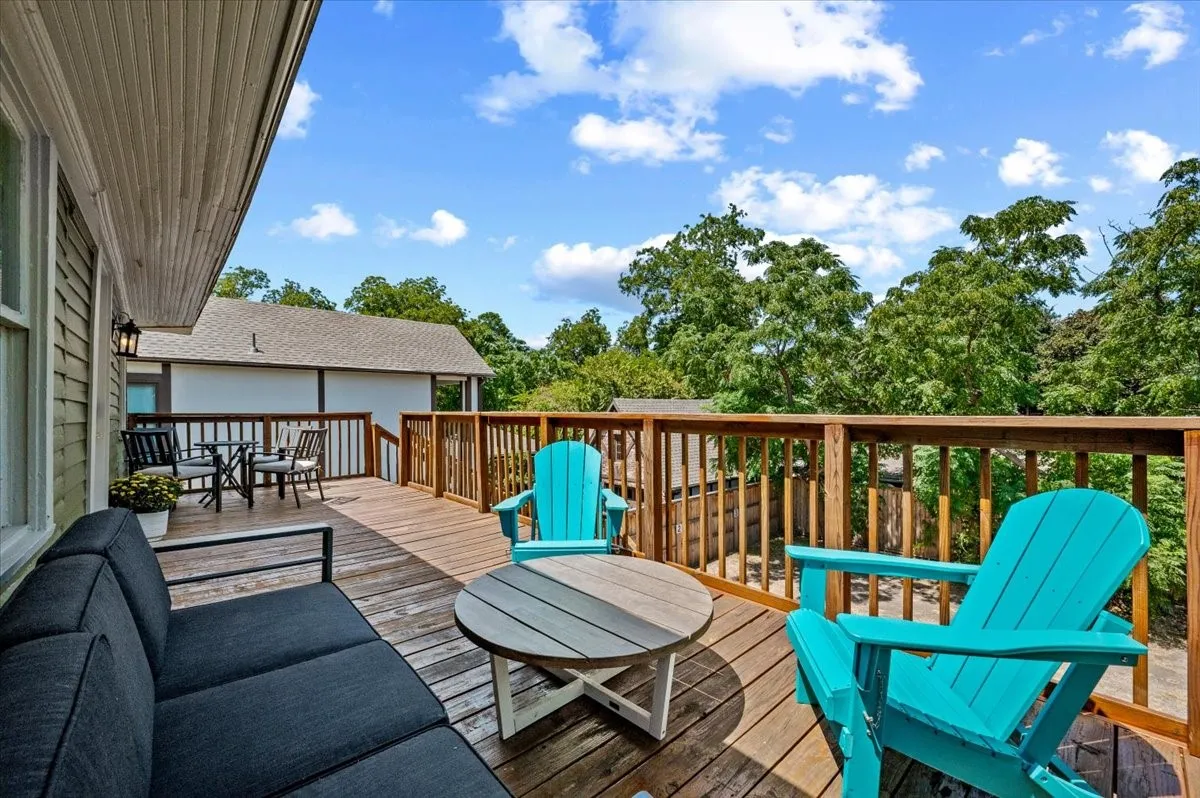 Expansive wood deck with a full wood railing system, integrated outdoor lighting, and ample space for dining