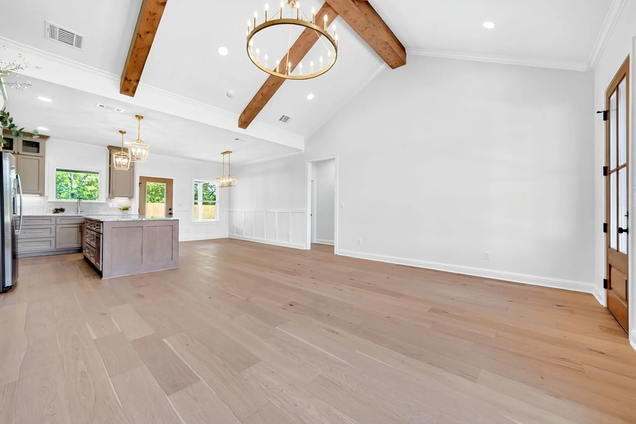 Vaulted ceilings with exposed wood beams, wood-finish flooring, recessed lighting, kitchen island with countertop, and modern cabinetry