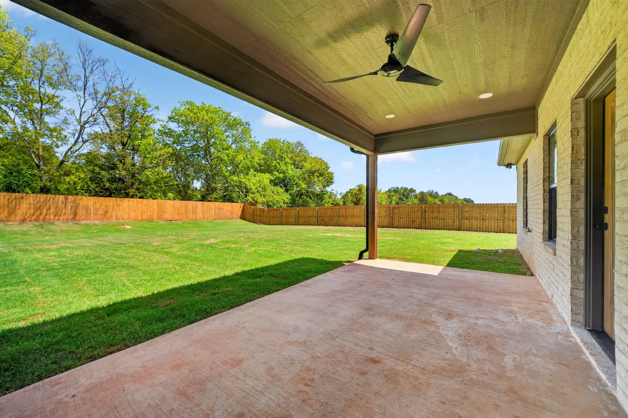 Expansive covered patio with concrete flooring, recessed lighting, and a ceiling fan