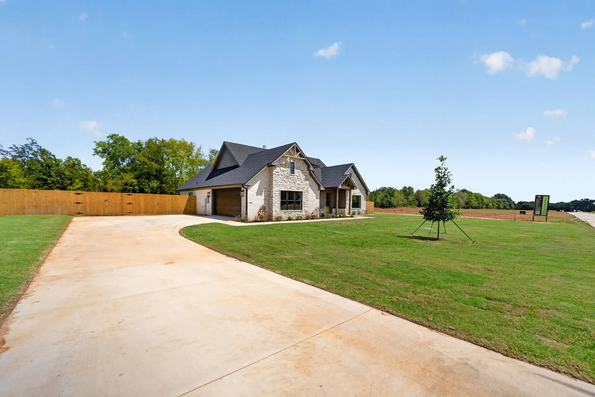Stone and brick exterior with dark trim accents, covered entry, and an attached garage