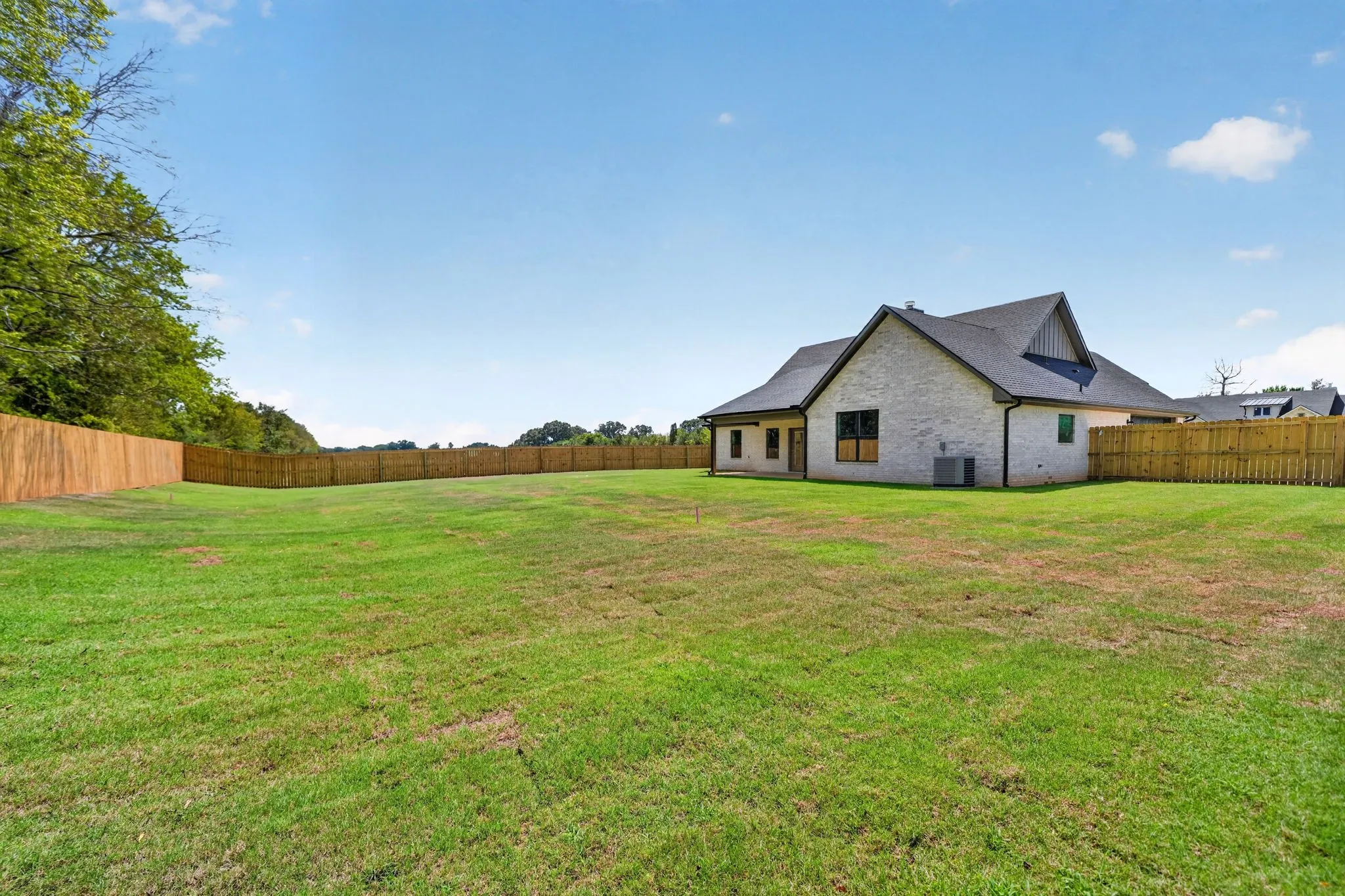 Expansive green lawn with a full privacy fence