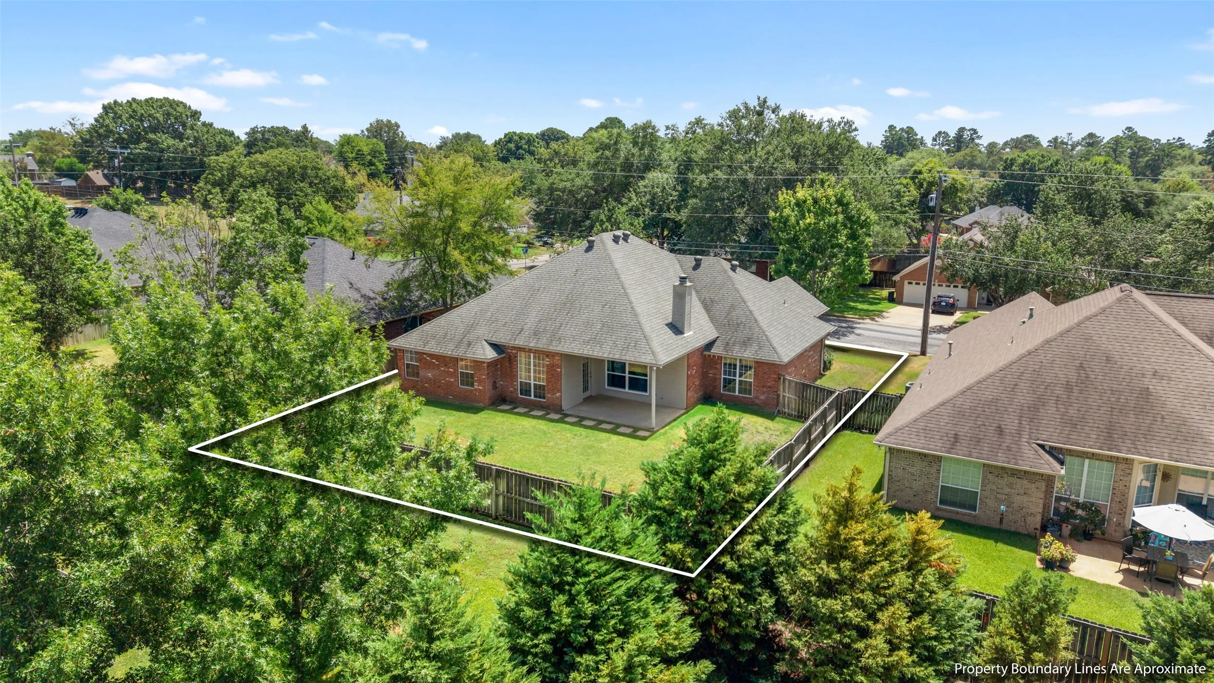 Brick exterior with a covered patio and fenced backyard