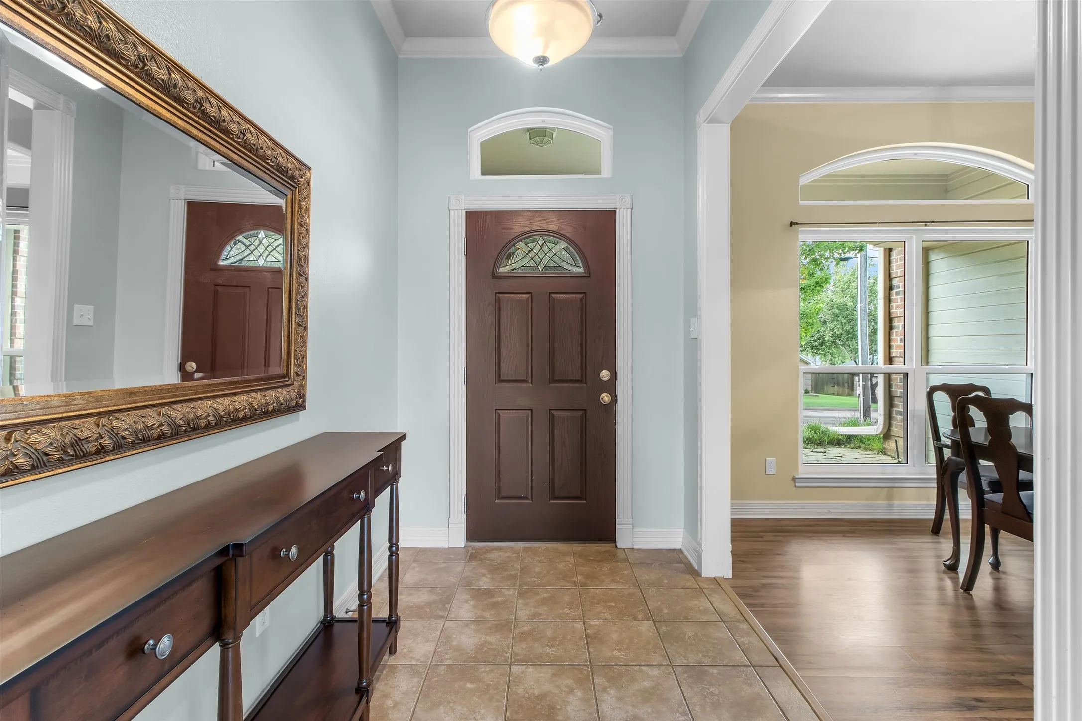 Entryway featuring tile flooring, a decorative front door with an arched transom window, and a ceiling-mounted light fixture