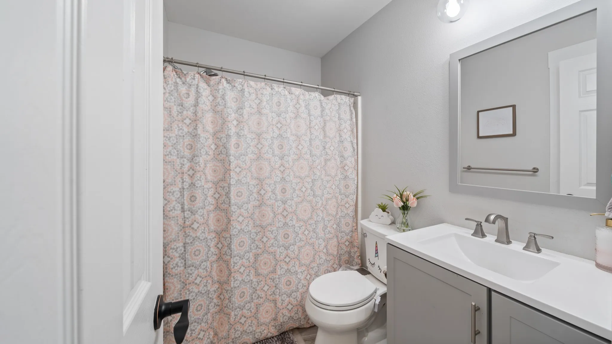 Single vanity with integrated sink, brushed nickel faucet, and a framed mirror