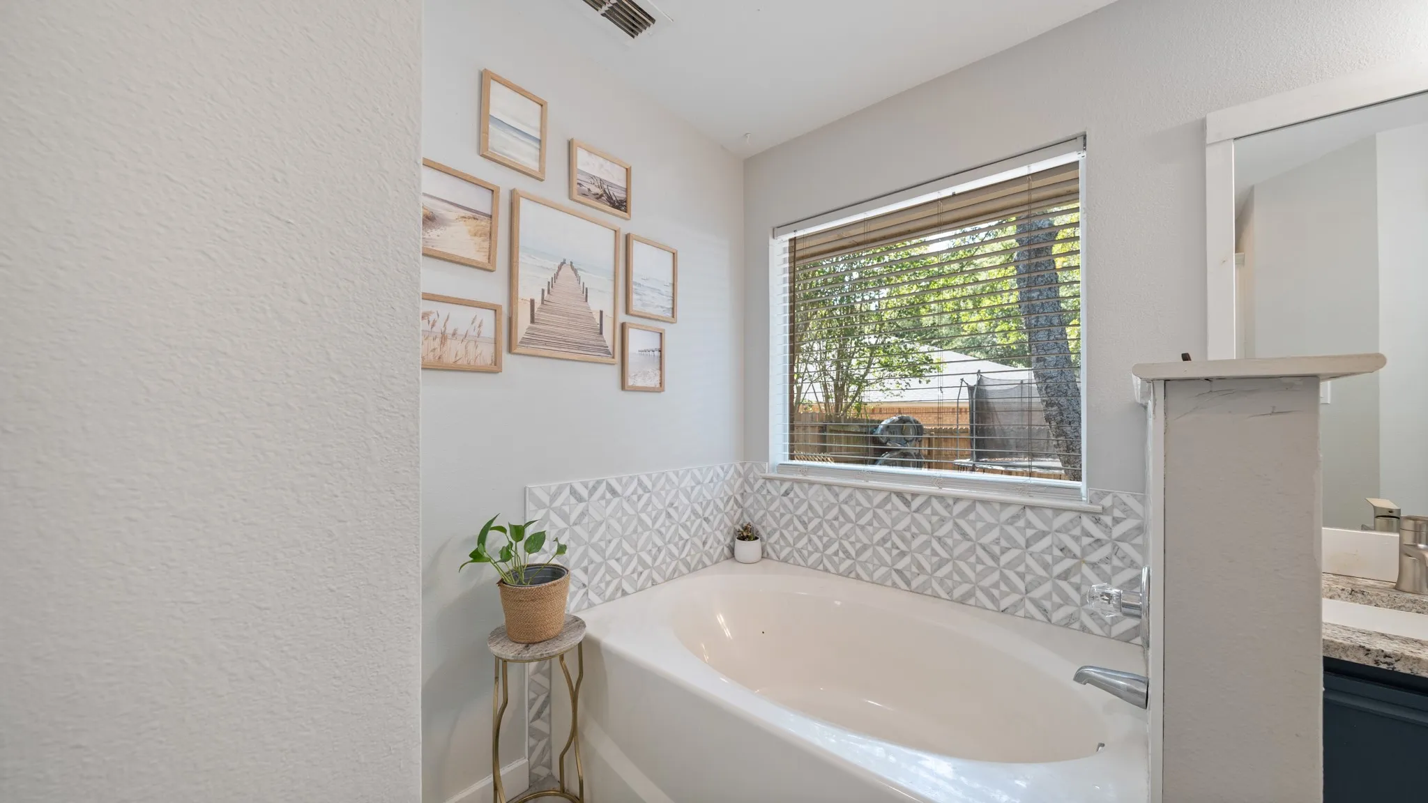 Built-in soaking tub with decorative tile surround and natural light