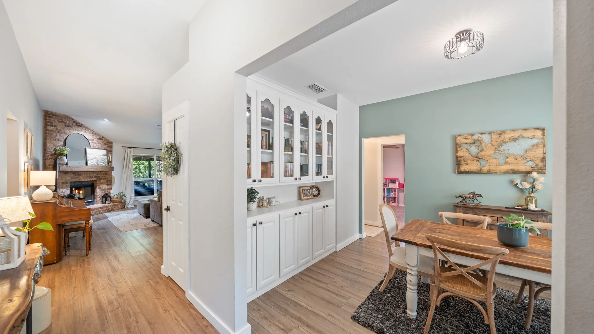 Vaulted ceilings, a brick-finish fireplace, and wood-finish flooring