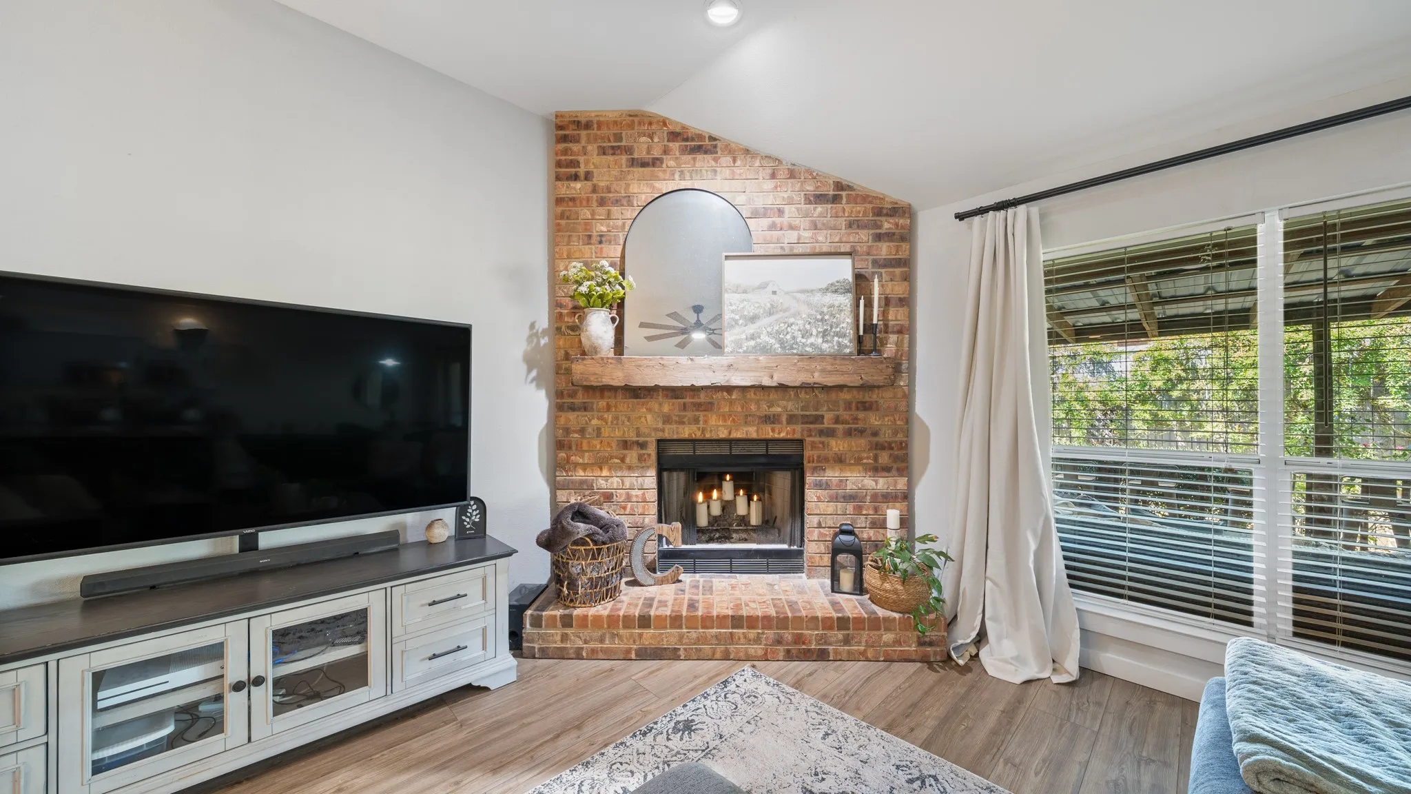 Brick corner fireplace with a wood mantel