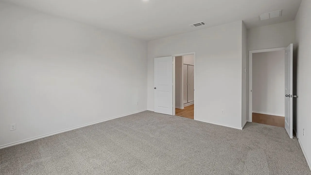 Spacious room featuring light gray carpet, white walls, and recessed lighting