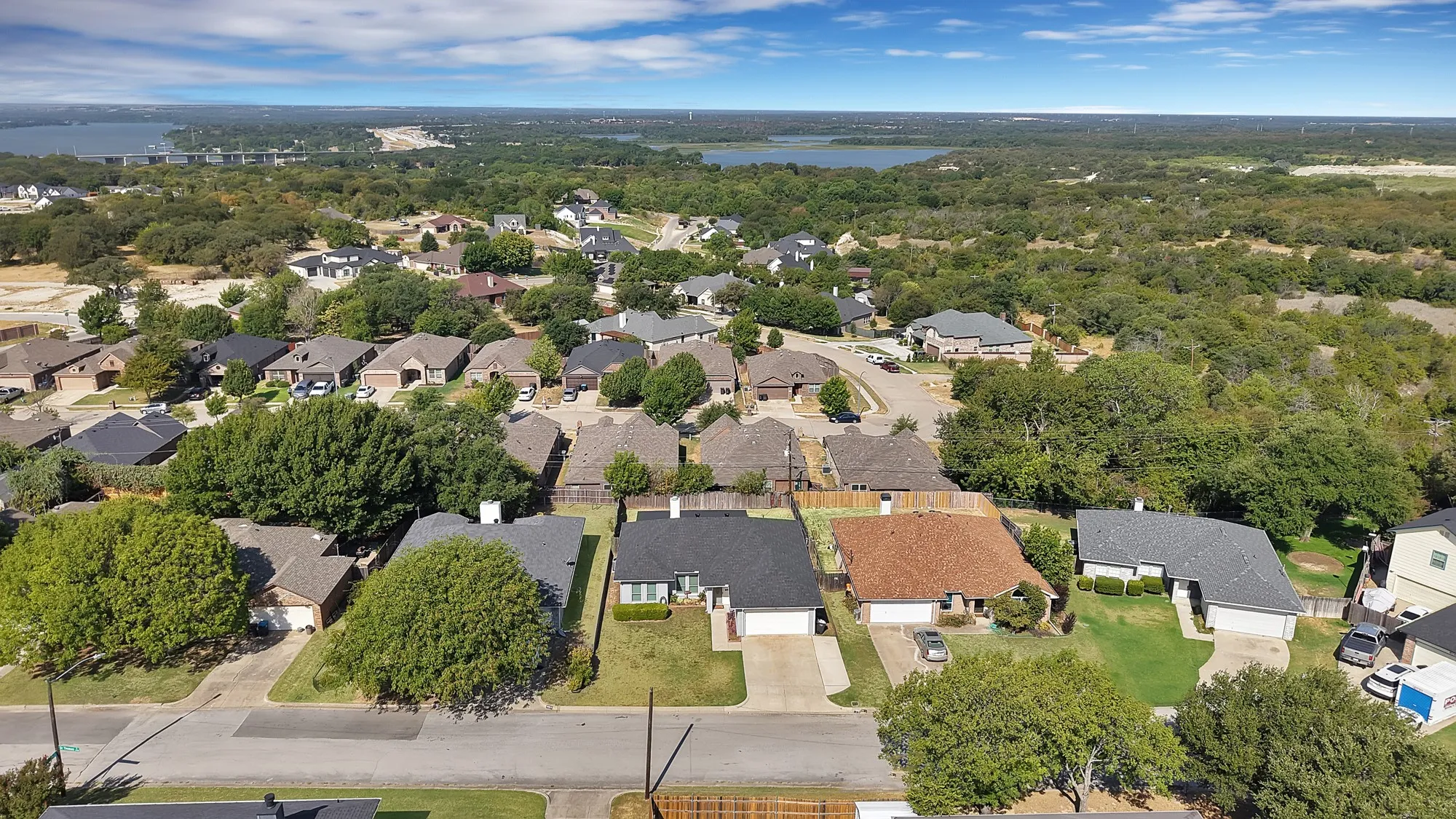 Residential neighborhood with mature trees, established streets, and distant water bodies