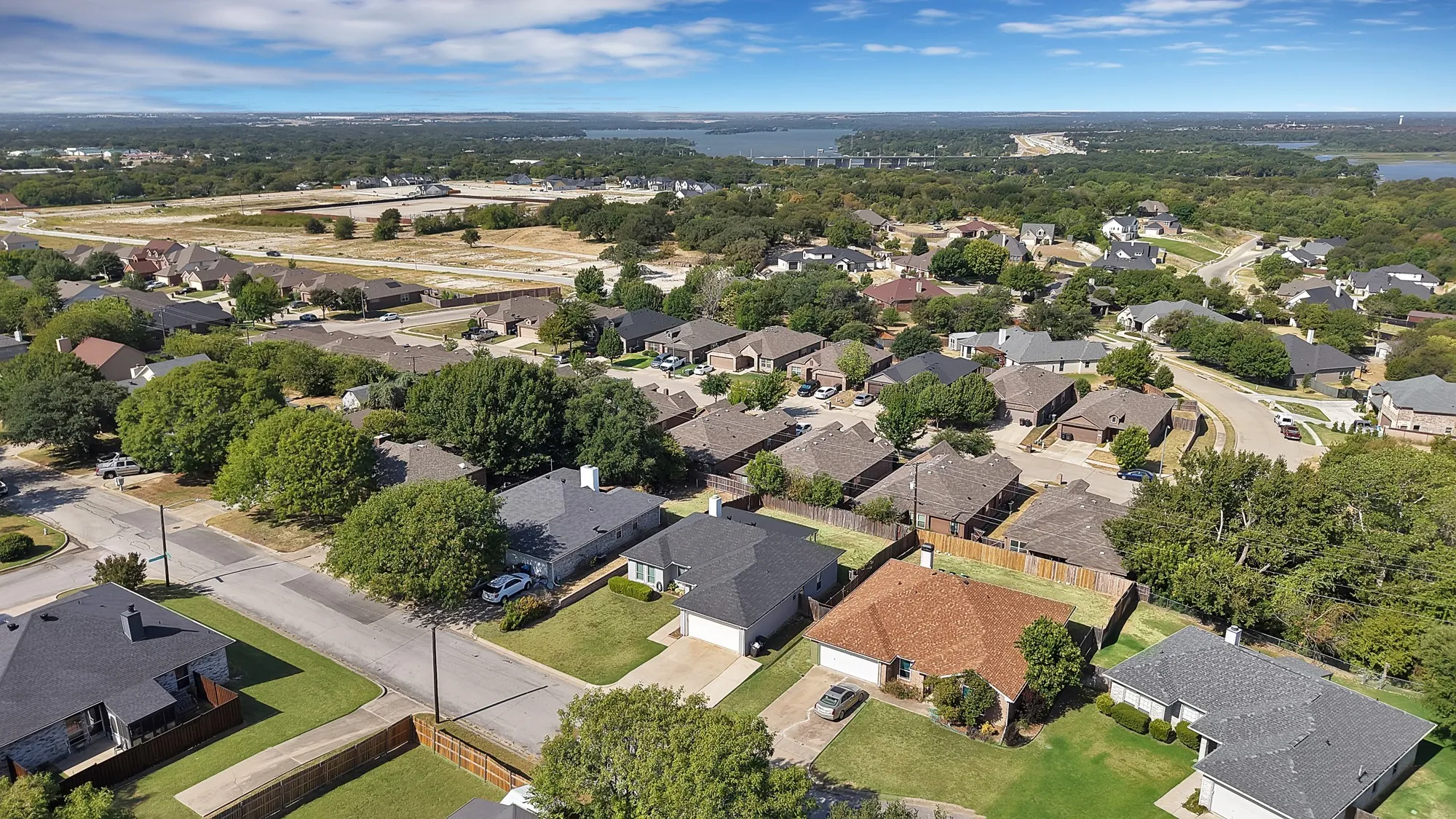 Residential neighborhood featuring mature trees, paved streets, and varied single-family homes