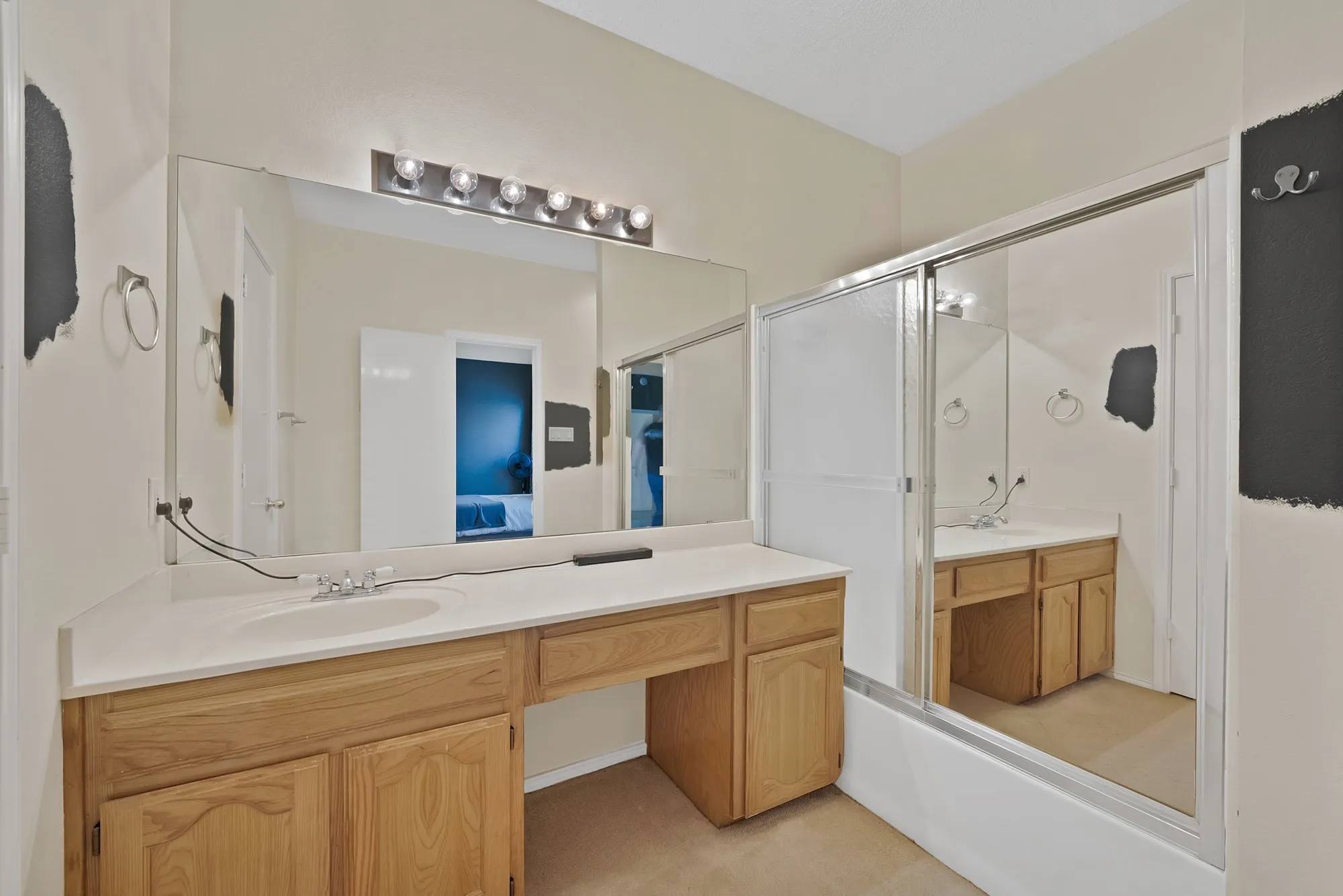 Expansive vanity with integrated sink, light-toned countertop, and wood-finish cabinetry