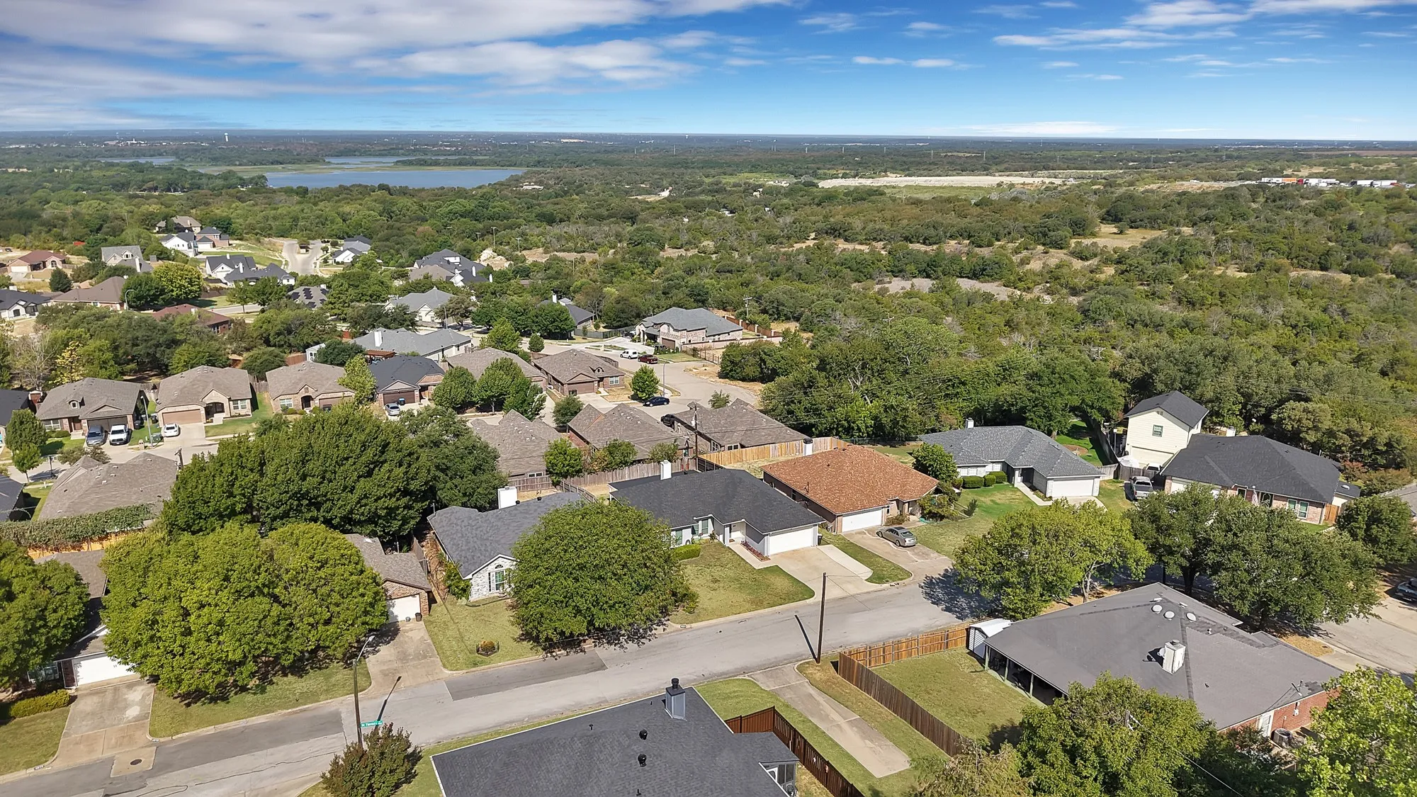 Aerial perspective showcasing a residential development with varied rooflines and surrounding mature trees