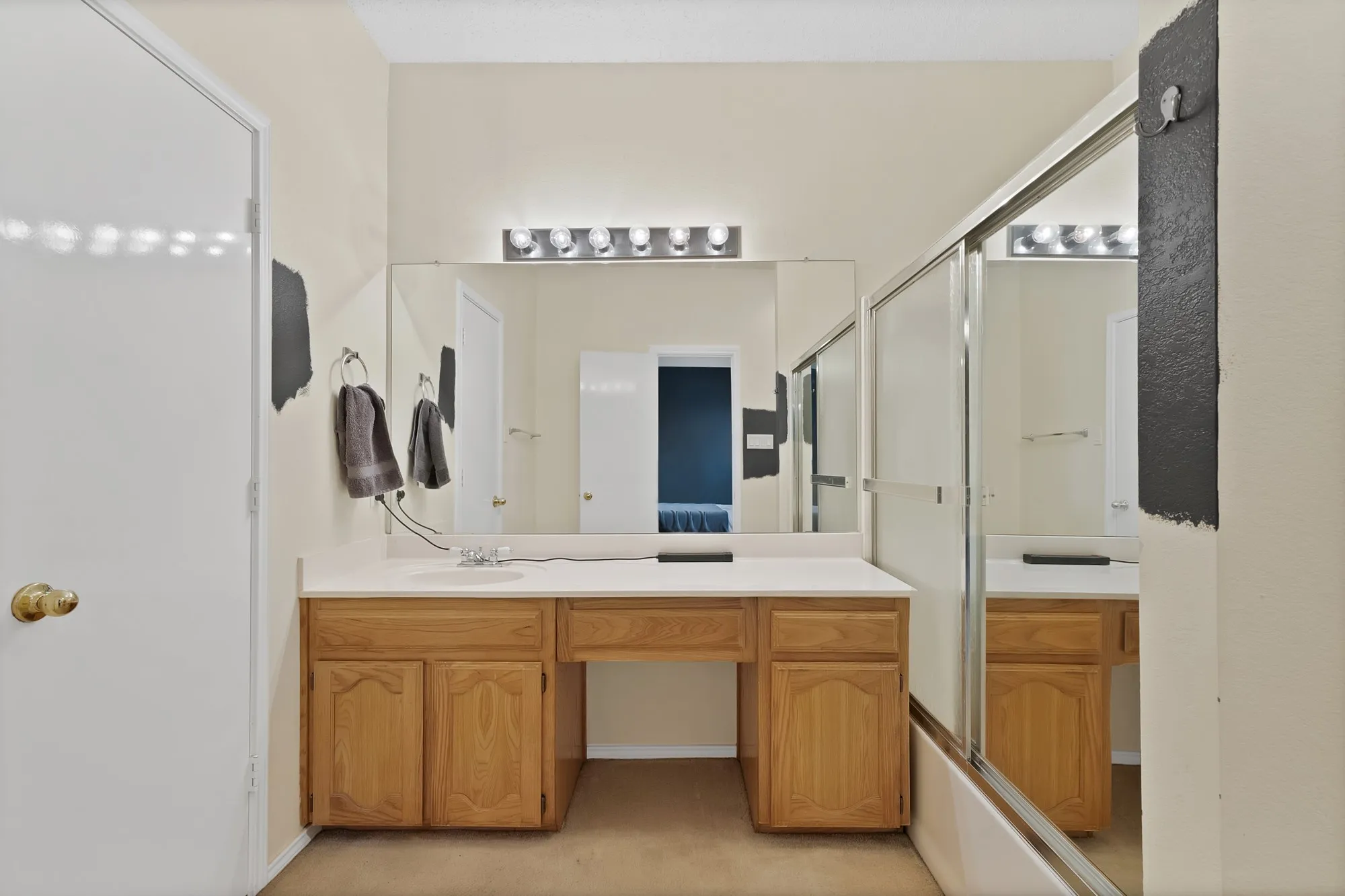 Dual vanity with wood-finish cabinetry and ample storage, paired with large framed mirrors and integrated lighting