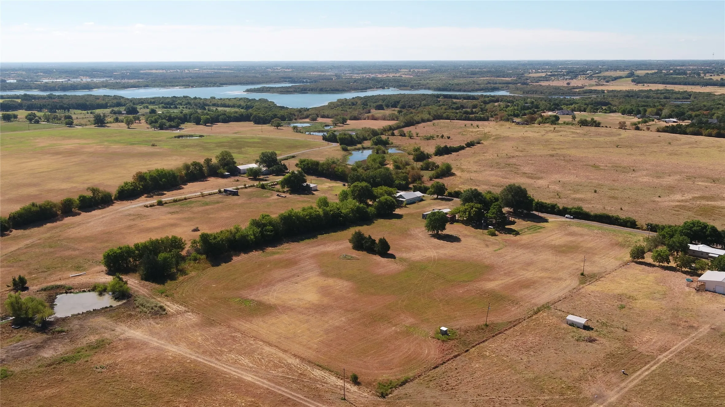 Expansive acreage with multiple structures, natural water features, and mature trees