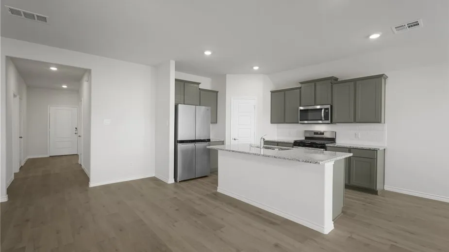 Kitchen featuring a central island, grey cabinetry, stainless steel appliances, and wood-finish flooring