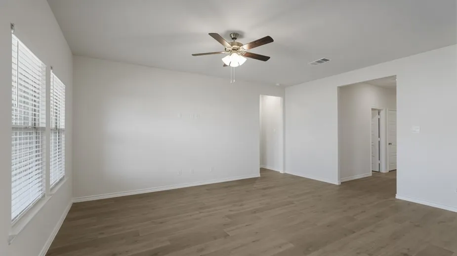 Wood-finish flooring, white walls, and a ceiling fan with integrated lighting