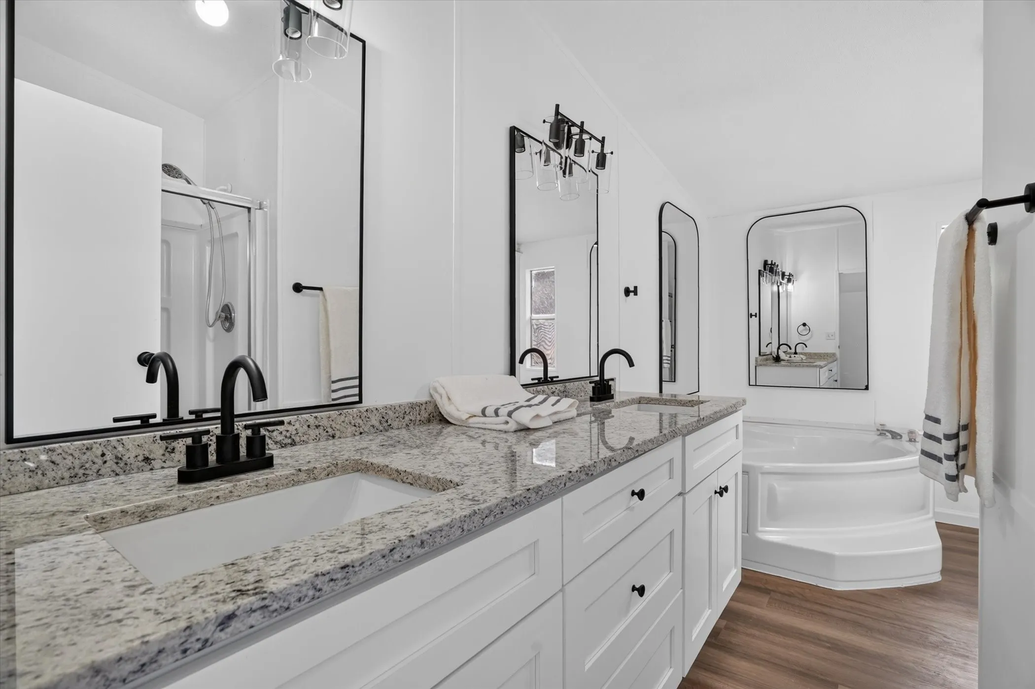 Dual vanity with granite countertops, undermount sinks, and matte black fixtures