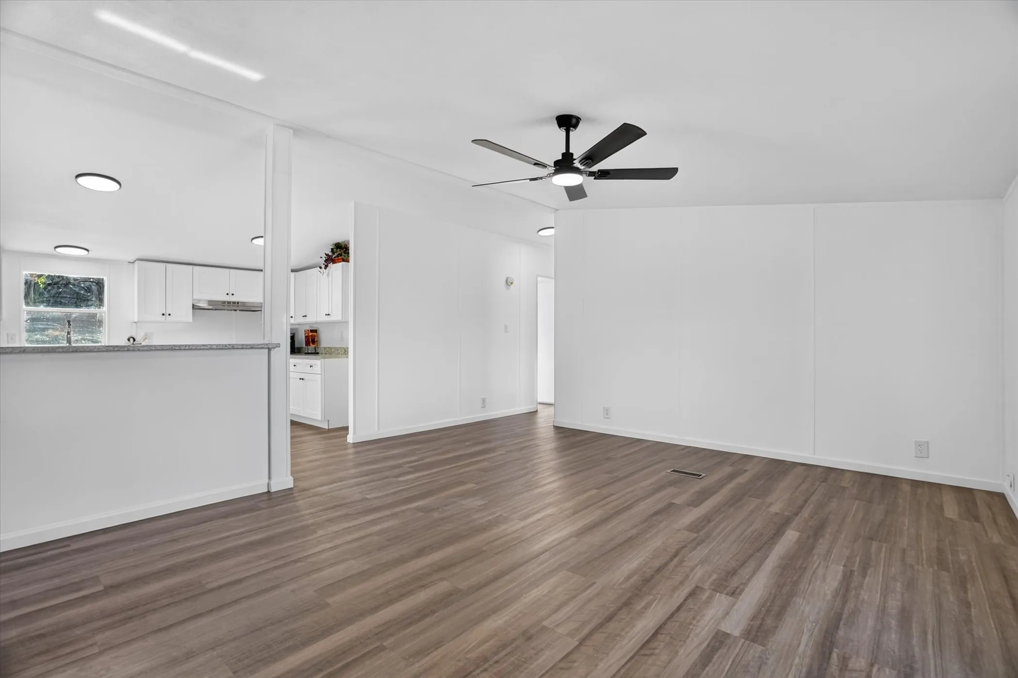 Wood-finish flooring, recessed lighting, and a ceiling fan