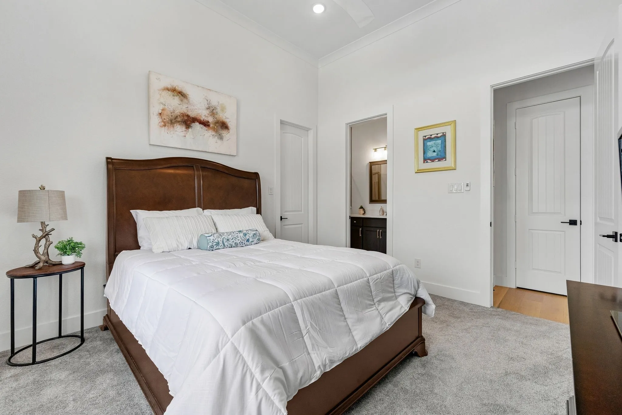 Recessed lighting, crown molding, gray carpet flooring, and white interior doors with black hardware