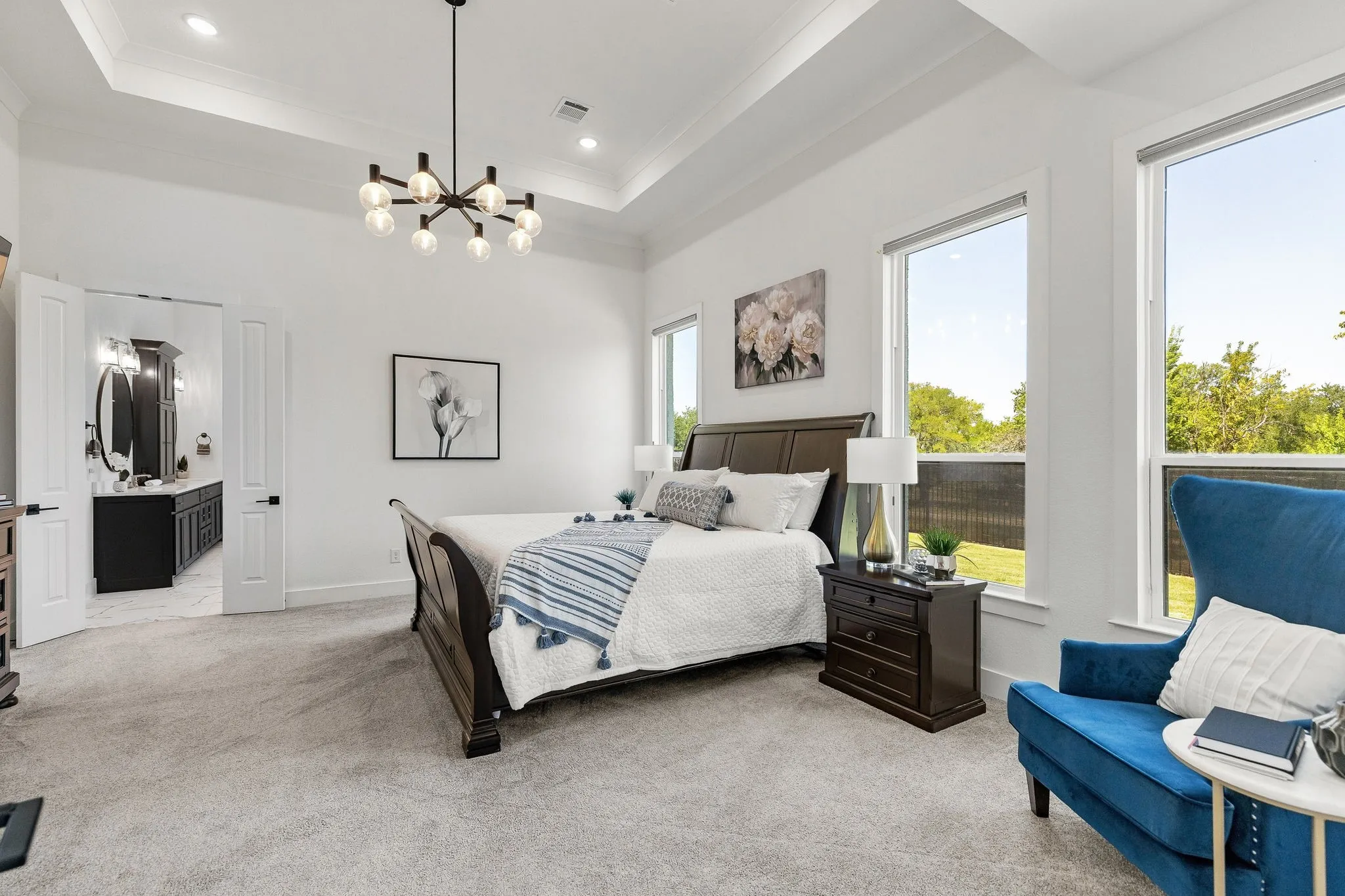 Tray ceiling with recessed lighting and a contemporary chandelier