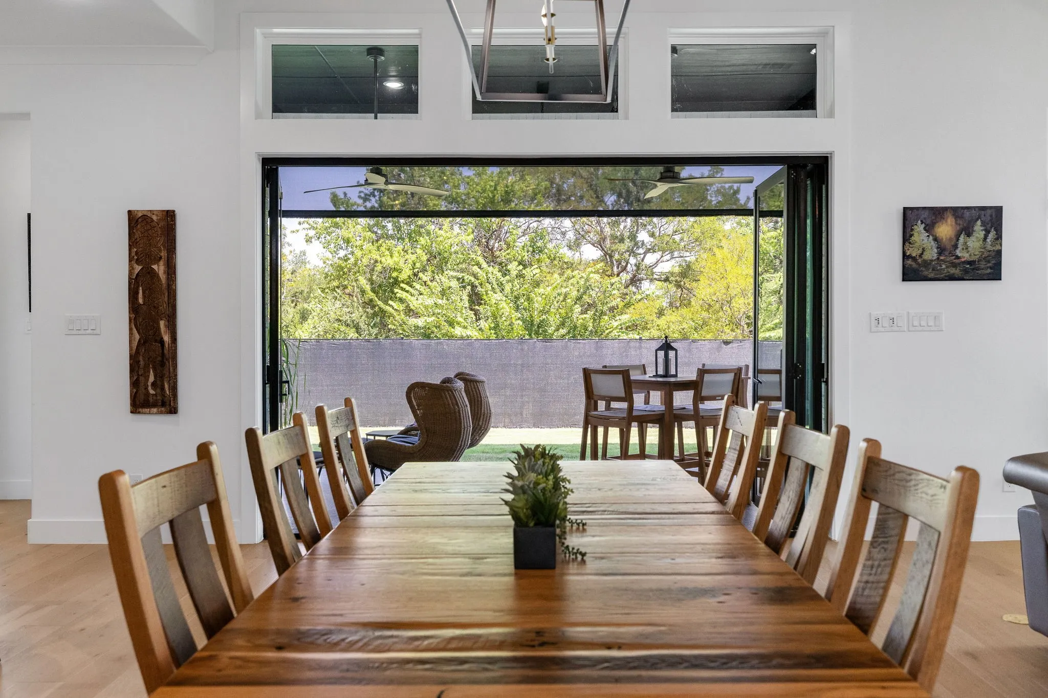 Sophisticated dining space showcasing a wood-finish table with seating for ten, illuminated by pendant lighting