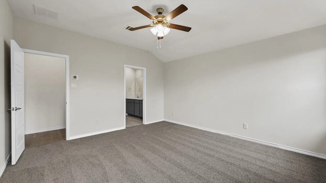 Carpeted room with a vaulted ceiling, ceiling fan with light fixture, and neutral wall tones