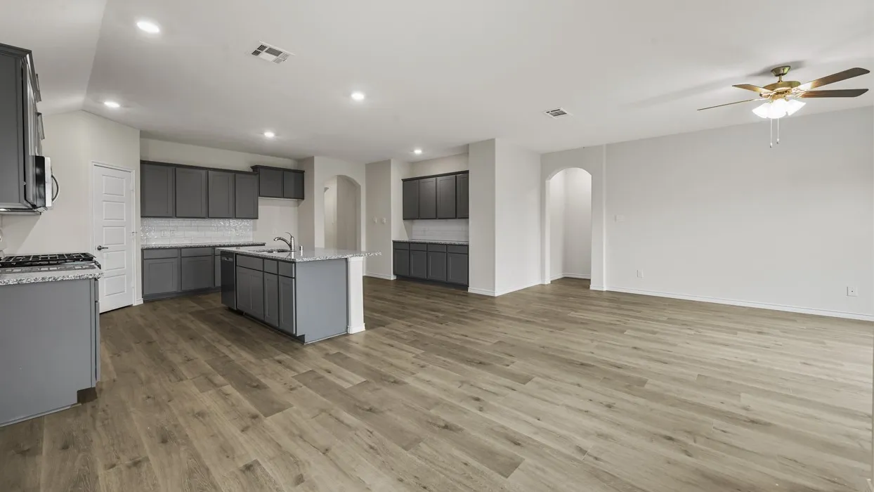 Open-concept kitchen and living area featuring wood-finish flooring, recessed lighting, and a ceiling fan