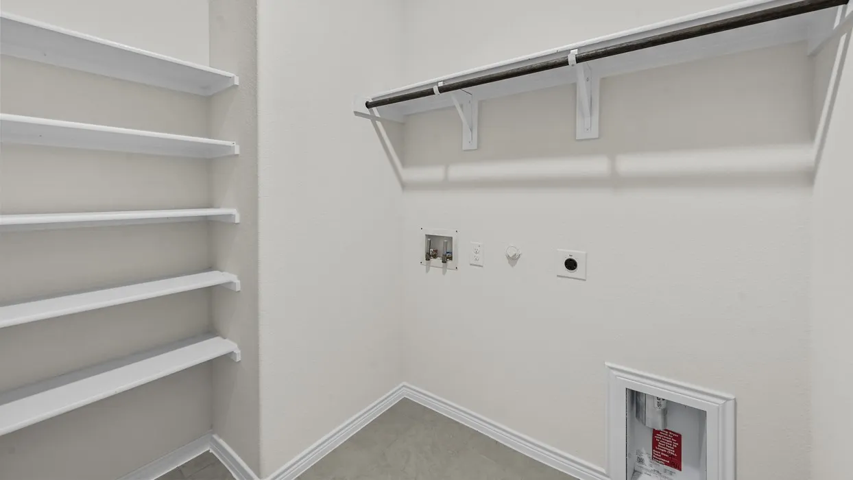 Built-in white shelving, integrated wall-mounted hanging rod, utility hookups, and tiled flooring