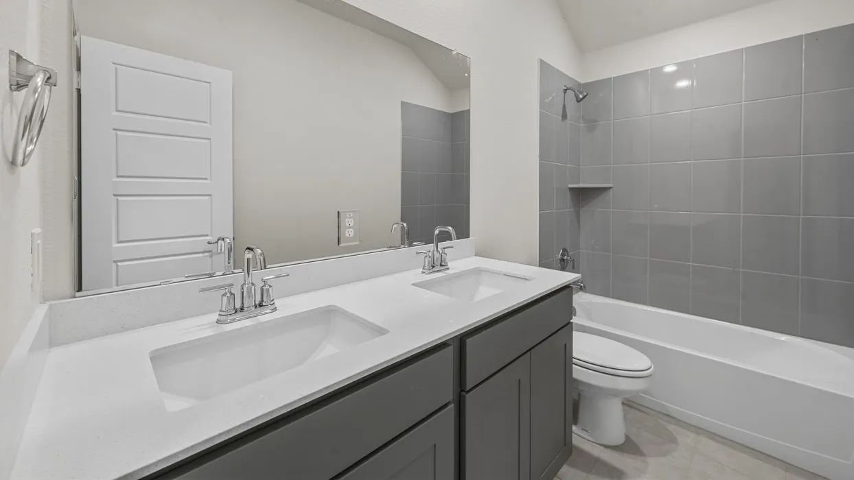 Dual vanity with white countertop, chrome fixtures, and gray cabinetry