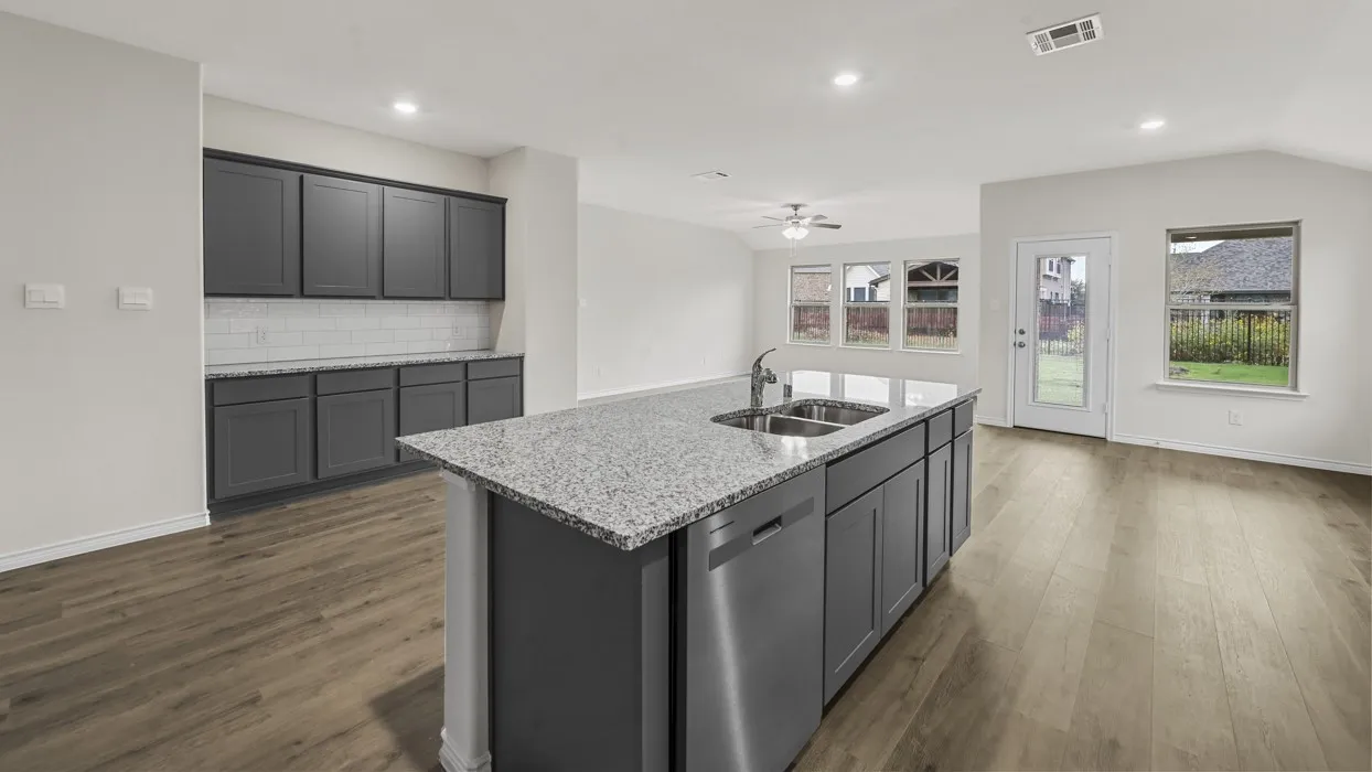 Kitchen island with dual basin sink, integrated dishwasher, and granite-style countertop