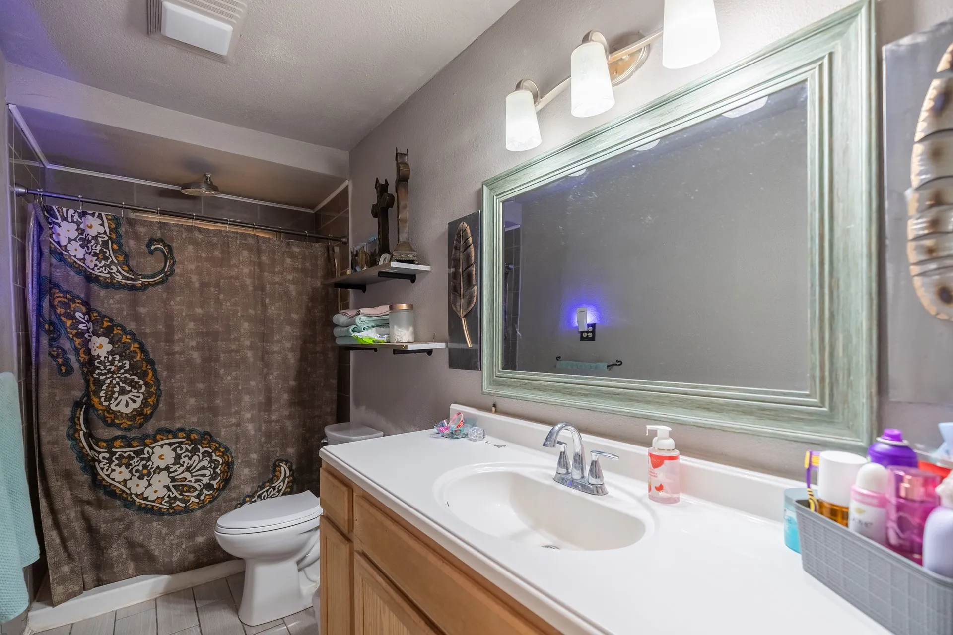 Vanity with integrated sink, framed mirror, and mounted light fixture
