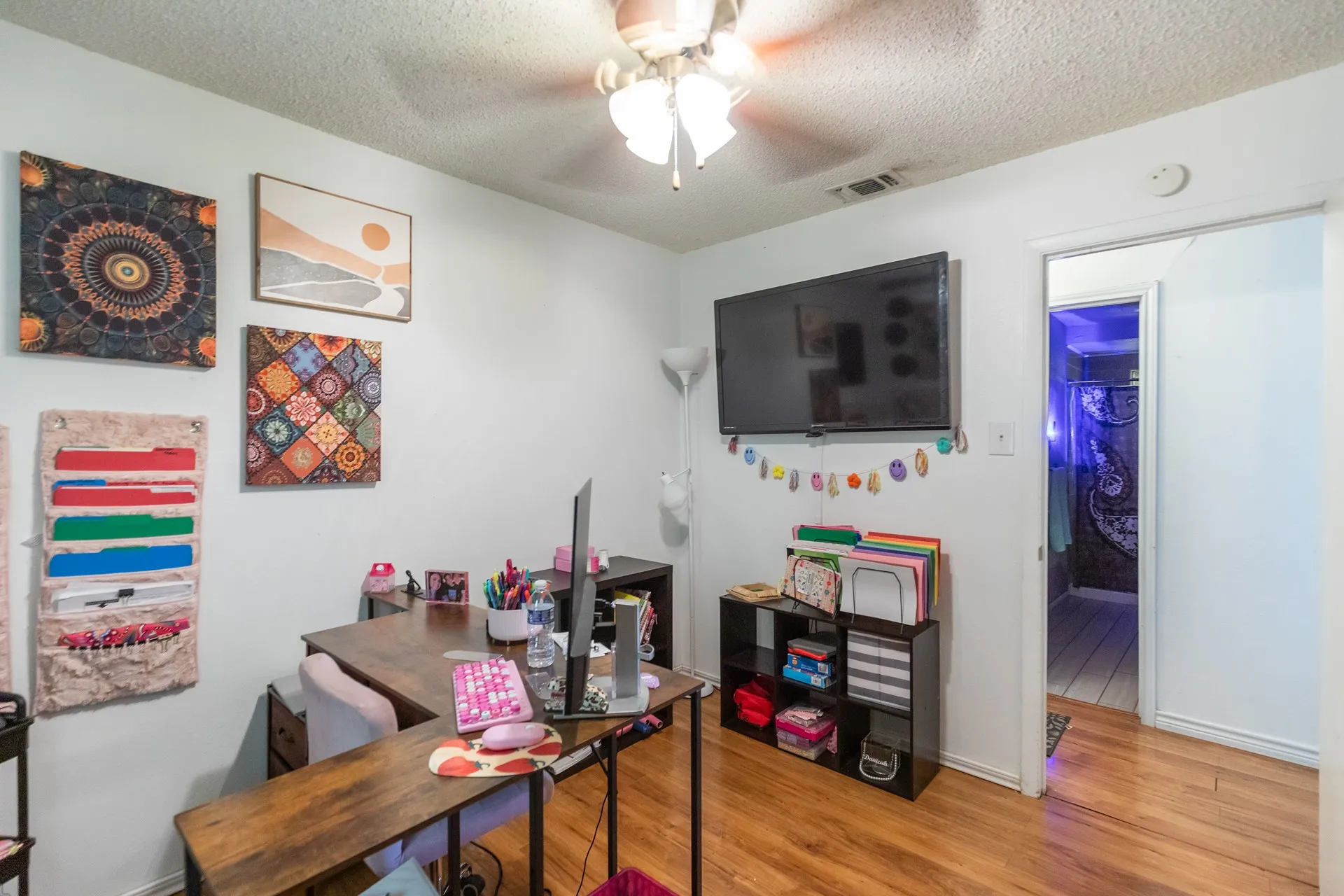 Hardwood-finish flooring, ceiling fan with integrated lighting, and white interior walls
