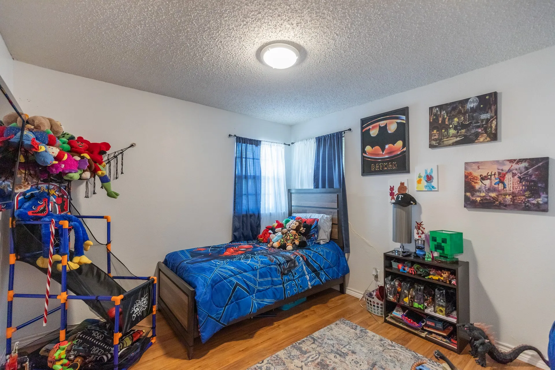 Wood-finish flooring, white walls, and a ceiling-mounted light fixture