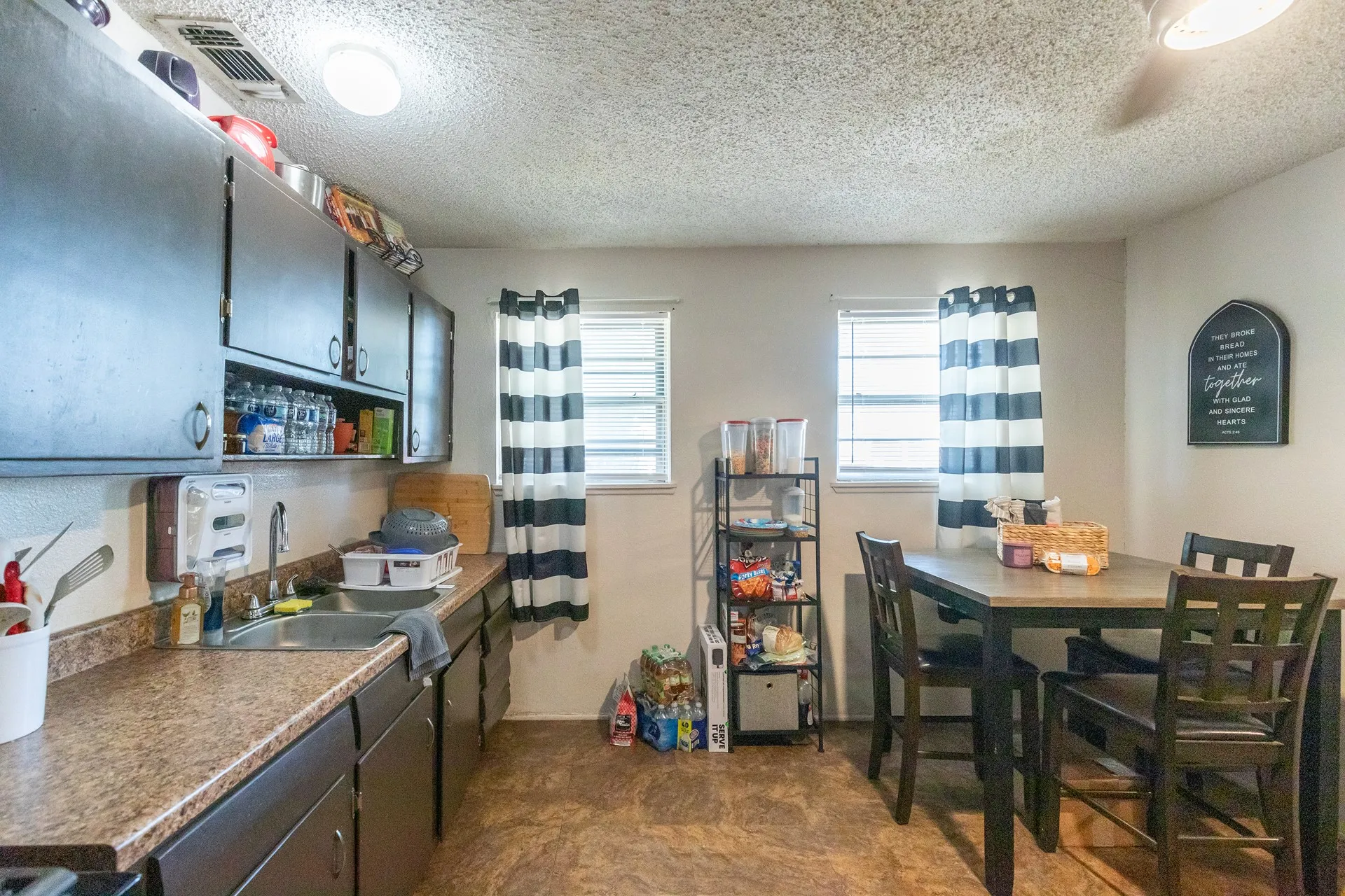 Galley kitchen featuring dark wood-finish cabinetry, a stainless steel sink, and wood-finish countertops